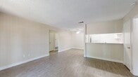 Located at 1498 Brookside Ave in Redlands, CA, this single-floor residence offers 2 bedrooms and 2 bathrooms within a well-organized and efficiently designed layout. The open-concept living room is bright and welcoming, featuring wood-look vinyl flooring, neutral beige walls, a textured ceiling, and a ceiling fan. Sliding glass doors lead directly to a private balcony, filling the space with natural light and providing outdoor views of surrounding greenery. The kitchen is positioned adjacent to the living area, separated by a half-wall pass-through counter with a granite-style surface. It includes white cabinetry, open shelving, a gas range, and a full-size refrigerator. Both bedrooms are carpeted and offer windows with views of mature trees and the surrounding neighborhood, creating a calm, comfortable atmosphere. Each bedroom benefits from closet storage, and the hallways connecting the rooms feature additional built-in cabinetry for extra storage. The two bathrooms are finished with wood-look flooring, white vanity cabinetry, large mirrors, and bright vanity lighting. Clean white trim and consistent neutral tones throughout the home create a cohesive, move-in-ready aesthetic.