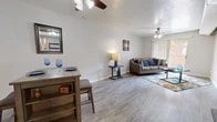 Located at 4300 Pan American Fwy NE in Albuquerque, New Mexico, this one-bedroom, one-bathroom unit offers a well-organized single-floor layout designed to maximize functionality. The open living area is anchored by durable wood-look flooring, neutral walls, and exposed ceiling beams that add architectural character. Ceiling fans are present throughout, ensuring year-round comfort. A sliding glass door in the living room fills the space with natural light and provides direct access to an outdoor patio area.

The galley-style kitchen is efficiently laid out with white cabinetry, a bold mosaic tile backsplash, dark appliances, and light wood-look flooring — offering a clean, modern aesthetic. A dedicated dining area sits adjacent, creating a natural flow between cooking and entertaining spaces.

The spacious bedroom features plush carpeting, a ceiling fan, and a large sliding glass door that brings in ample natural light. A closet and additional hallway storage provide practical organization options. The office adds versatile flex space suitable for work or study.

The bathroom is finished with dark stone-look countertops, a vanity with modern hardware, a full tub-shower combination, and wood-look flooring, completing the cohesive design found throughout the home.