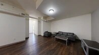 Located at 5 Court St in downtown Binghamton, NY, this thoughtfully laid-out unit offers 3 bedrooms, 4 bathrooms, a game room, and 6 closets across a generously sized single floor. The open common area features rich, dark hardwood flooring and exposed ductwork that lends an industrial character to the space. Structural beams and varied ceiling heights add architectural interest throughout, while flush-mounted lighting provides consistent illumination. The common area flows naturally into a hallway that connects the private rooms, creating a well-organized layout. Each bedroom is carpeted and filled with natural light through large double-hung windows, offering views of the surrounding neighborhood. The bedrooms include dedicated desk space, making them well-suited for study or work. Six closets distributed throughout the unit provide ample storage. The four bathrooms feature walk-in shower stalls, terrazzo-style flooring, and clean, minimalist finishes. A dedicated game room adds flexible living space beyond the standard layout. The unit's neutral color palette of whites and soft grays throughout creates a clean, modern ambiance that complements its urban setting in the heart of Binghamton.