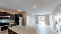 Located at County Road D E in Maplewood, Minnesota, this single-floor residence offers a well-designed open-concept layout that seamlessly connects the kitchen, dining, and living areas. The kitchen is a standout feature, showcasing rich dark-stained cabinetry, light granite countertops, a central island, and a full suite of stainless steel appliances including a refrigerator, electric range, microwave, and dishwasher. Light hardwood-style flooring runs throughout the main living areas, lending a clean and contemporary feel. The spacious living room is bathed in natural light from a large sliding glass door that opens to a private balcony overlooking lush, tree-lined surroundings. Bedrooms are carpeted for comfort, with generous proportions and large windows offering neighborhood views. The primary suite includes a walk-in closet outfitted with wire shelving systems and a private en-suite bathroom featuring a double-sink granite vanity and a tub/shower combination. A second full bathroom also features a matching granite vanity and in-unit storage. Neutral warm-toned walls throughout create a calm, inviting ambiance. This thoughtfully appointed residence combines modern finishes with functional design in a convenient Maplewood location.