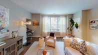 This single-floor residence offers a thoughtfully designed layout with distinct living spaces that balance comfort and functionality. The open-concept kitchen is a standout feature, showcasing dark espresso cabinetry extending to the ceiling, granite countertops, a curved breakfast bar peninsula, subway tile backsplash, stainless steel appliances, and pendant lighting above — all complemented by rich hardwood-style flooring.

The living area provides generous space for entertaining, with large windows dressed in sheer curtains that invite natural light and views of the surrounding area. Hardwood-style flooring continues throughout, adding warmth and visual continuity.

Multiple bedrooms offer carpeted floors, ceiling fans or chandelier fixtures, and large windows with sheer drapery that enhance the bright, airy atmosphere. Each room provides a calm, neutral palette suited for relaxation.

Both bathrooms are finished consistently with dark vanity cabinetry, granite countertops, undermount sinks, and hardwood-style flooring. Each includes a full tub-shower combination with tile surround, providing a clean and cohesive aesthetic throughout the residence.