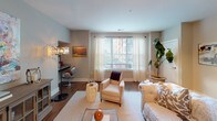 This single-floor residence offers a thoughtfully designed layout with distinct living spaces that balance comfort and functionality. The open-concept kitchen is a standout feature, showcasing dark espresso cabinetry extending to the ceiling, granite countertops, a curved breakfast bar peninsula, subway tile backsplash, stainless steel appliances, and pendant lighting above — all complemented by rich hardwood-style flooring.

The living area provides generous space for entertaining, with large windows dressed in sheer curtains that invite natural light and views of the surrounding area. Hardwood-style flooring continues throughout, adding warmth and visual continuity.

Multiple bedrooms offer carpeted floors, ceiling fans or chandelier fixtures, and large windows with sheer drapery that enhance the bright, airy atmosphere. Each room provides a calm, neutral palette suited for relaxation.

Both bathrooms are finished consistently with dark vanity cabinetry, granite countertops, undermount sinks, and hardwood-style flooring. Each includes a full tub-shower combination with tile surround, providing a clean and cohesive aesthetic throughout the residence.