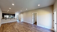 This single-story home offers a thoughtfully designed open floor plan that maximizes its generous square footage. Wood-look flooring flows consistently throughout the main living areas, complemented by neutral-toned walls and recessed lighting that create a bright, welcoming ambiance.

The kitchen is a standout feature, showcasing rich espresso cabinetry paired with light granite countertops and a full suite of stainless steel appliances, including an electric range, built-in microwave, and refrigerator. A deep undermount sink and ample counter space add to the kitchen's practicality.

The bedrooms are well-sized, each featuring ceiling fans and natural light from windows with blinds. The primary bedroom benefits from a spacious walk-in closet with multi-level hanging rods and shelving. The bathrooms include a clean tub/shower combination with chrome fixtures.

Interior doors are finished in white with distinctive black hardware, adding a modern contrast throughout. A dedicated laundry area houses a full-size washer and dryer with overhead cabinetry. The attached garage provides additional storage and convenient direct interior access, completing this functional and attractive home.
