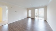 This single-floor residence offers a thoughtfully designed layout with a cohesive aesthetic carried throughout. The kitchen serves as a standout feature, outfitted with dark espresso shaker cabinetry reaching toward the ceiling, granite-style countertops, and a full suite of stainless steel appliances including a refrigerator, range, microwave, and dishwasher. A kitchen island provides additional workspace and flows naturally into the open living area, which features warm wood-look hard-surface flooring and crown molding accents. Pendant lighting above the island adds an inviting ambiance to the space.

The living area connects to a dedicated in-unit laundry closet with a stacked washer and dryer. Bedrooms are finished with plush wall-to-wall carpeting and feature windows that invite natural light. One bedroom includes a generously sized walk-in closet with wire shelving systems offering ample storage.

The bathrooms maintain the dark cabinetry theme, each featuring white countertops, large vanity mirrors, and distinctive black-and-white hexagonal mosaic tile flooring. At least one bathroom includes a tub-shower combination, while another offers an extended double-sink vanity, adding everyday convenience throughout the home.