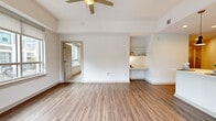 Located in the heart of Charlotte, NC, this single-floor residence at 355 W Martin Luther King Jr Blvd offers a thoughtfully designed open-concept layout filled with natural light. The spacious living area features warm wood-look flooring, a ceiling fan, built-in shelving, and a dedicated desk nook — ideal for both relaxing and working from home. Large windows and sliding glass doors open to a private balcony, framing views of the surrounding cityscape and greenery.

The modern kitchen is a standout, boasting a generous center island with pendant lighting, crisp white cabinetry, a classic tile backsplash, and stainless steel appliances including a French door refrigerator, range, and microwave. Recessed lighting enhances the clean, contemporary aesthetic throughout.

The bedrooms are carpeted for comfort and feature ample natural light through large windows overlooking the urban streetscape. Each bedroom is complemented by an en-suite bathroom with vanity storage. The overall design palette is bright and neutral, creating a calm, welcoming ambiance throughout. This well-appointed residence combines modern finishes with functional design in a prime Charlotte location.