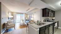 Located at 555 Church Street in the heart of Nashville, TN, this one-bedroom, one-bathroom unit offers a well-designed open-concept layout across a single floor. The combined kitchen and living area serves as the centerpiece of the space, where a peninsula kitchen with granite countertops, dark espresso cabinetry, a tile backsplash, and stainless steel appliances flows seamlessly into the living room. Light wood-style flooring runs throughout, lending a clean, modern aesthetic. The living room is bright and welcoming, drawing in natural light through a large sliding glass door that opens to a private balcony with city views. The spacious primary bedroom features neutral-toned walls, a textured ceiling, wood-style flooring, and a window that allows for ample natural light. A dedicated closet provides practical storage. The bathroom is well-appointed with a wide granite-topped vanity, dark cabinetry with brushed nickel hardware, a large mirror, and wood-style tile flooring. A separate entry foyer with decorative sidelights offers an elegant transition into the unit. The overall ambiance is contemporary and refined, with a cohesive neutral palette throughout.