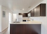 Located at 35410 Van Born Road in Wayne, Michigan, this single-floor, 2-bedroom, 1-bathroom unit offers a clean and functional layout with consistent light wood-look flooring throughout. The open-concept kitchen and living area forms the heart of the space, featuring a peninsula with dark espresso cabinetry, light countertops, recessed lighting, and white appliances including a refrigerator, range, and microwave. The living area benefits from natural light through a large window and a glass exterior door. Both bedrooms are bright and well-proportioned, with the primary bedroom offering a generously sized closet. Windows in the bedrooms provide outdoor views and allow natural light to fill the rooms. The bathroom continues the dark cabinetry theme with a matching vanity, light countertop, mirror, and overhead lighting. A dedicated laundry room houses a stacked washer and dryer unit alongside an upper cabinet for additional storage. Crisp white walls and cohesive finishes throughout give the space a fresh, move-in-ready feel. The thoughtful layout maximizes functionality while maintaining an open and airy ambiance across all rooms.