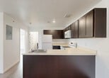 Located at 35410 Van Born Road in Wayne, Michigan, this single-floor, 2-bedroom, 1-bathroom unit offers a clean and functional layout with consistent light wood-look flooring throughout. The open-concept kitchen and living area forms the heart of the space, featuring a peninsula with dark espresso cabinetry, light countertops, recessed lighting, and white appliances including a refrigerator, range, and microwave. The living area benefits from natural light through a large window and a glass exterior door. Both bedrooms are bright and well-proportioned, with the primary bedroom offering a generously sized closet. Windows in the bedrooms provide outdoor views and allow natural light to fill the rooms. The bathroom continues the dark cabinetry theme with a matching vanity, light countertop, mirror, and overhead lighting. A dedicated laundry room houses a stacked washer and dryer unit alongside an upper cabinet for additional storage. Crisp white walls and cohesive finishes throughout give the space a fresh, move-in-ready feel. The thoughtful layout maximizes functionality while maintaining an open and airy ambiance across all rooms.