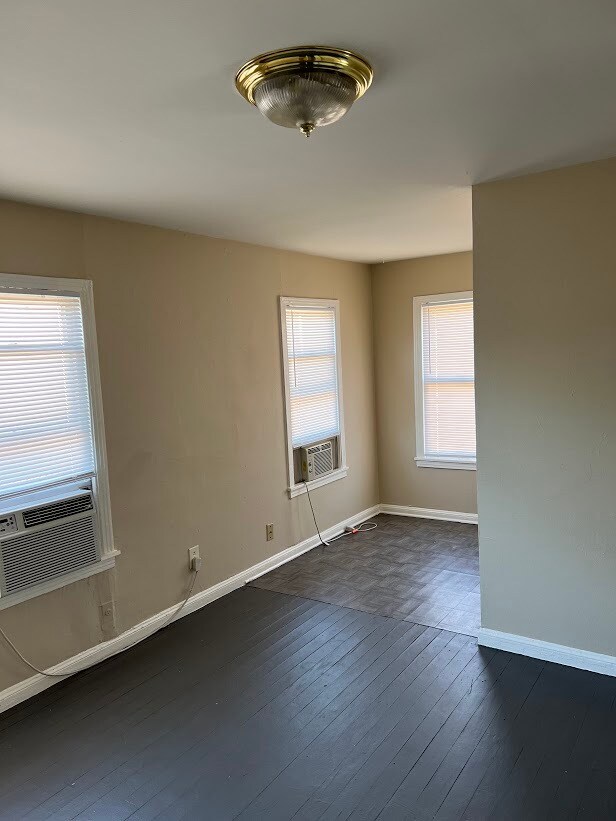 Sala de estar, vista parcial. Suelo de madera y linóleo en la cocina. - 1162 W 24th St