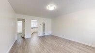 Located at 345 S Westlake Ave in the Westlake neighborhood of Los Angeles, this efficiently designed single-floor unit offers a clean, modern aesthetic across four well-defined spaces. Light wood-style plank flooring runs consistently throughout, creating a cohesive and airy feel that maximizes the sense of space.

The living room serves as the heart of the unit, featuring bright white walls, a textured ceiling, and a window that allows natural light and greenery views to fill the room. A wall-mounted AC unit ensures year-round comfort, while clean baseboards and a neutral palette keep the space feeling open and versatile.

The kitchen is thoughtfully laid out with white cabinetry, grey laminate countertops, and a full suite of stainless steel appliances including a gas range, over-range microwave, and refrigerator. A window above the sink brings in natural light, enhancing the clean, functional workspace.

The bathroom continues the bright, white theme with a full bathtub and shower combination, a toilet, and a vanity with matching grey countertop. A frosted window provides natural ventilation while maintaining privacy.

A hallway connects the spaces efficiently, contributing to the unit's smart, compact layout. Overall, the space presents a fresh, move-in-ready environment with consistent finishes and practical amenities throughout.