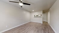 Located at 1550 Blalock Rd in Houston, TX, this single-story, one-bedroom, two-bathroom residence offers a well-organized layout designed for functional everyday living. The combined kitchen and living room serves as the heart of the home, featuring light-toned luxury vinyl plank flooring that runs throughout. The living area is brightened by a front-facing window with blinds and is equipped with a ceiling fan. A pass-through window connects the living space to the kitchen, which impresses with white shaker-style cabinetry, gray subway tile backsplash, white quartz countertops, a stainless steel sink, and black appliances including a refrigerator, stove, and dishwasher. A dedicated pantry provides additional storage. The spacious primary bedroom includes its own ceiling fan, natural light from a window, and easy access to a hallway that connects to both bathrooms. One bathroom features a full tub-shower combination with white tile surround, while the other includes a white vanity with a clean, modern finish. A dedicated laundry room houses a stacked washer and dryer unit. A closet rounds out the thoughtfully arranged floor plan, making efficient use of every square foot in this compact yet well-appointed home.