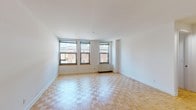 Located at 201 Broad Street in downtown Stamford, Connecticut, this two-bedroom, two-bathroom residence offers a well-designed single-floor layout with consistent finishes throughout. The living area is bright and spacious, showcasing classic parquet hardwood flooring and a row of large windows that fill the space with natural light and provide views of the surrounding cityscape. The clean white walls and open feel lend the space a fresh, airy character.

The kitchen is efficiently designed in a U-shaped configuration, featuring white cabinetry that extends to the ceiling for ample storage, dark granite countertops, and a full suite of stainless steel appliances, including a refrigerator, dishwasher, microwave, and electric range. Tile flooring and under-cabinet lighting add functional detail to the space.

Both bedrooms continue the parquet flooring found throughout the residence and are served by generous natural light from double windows with views of the neighborhood. One bedroom includes a dedicated closet and direct access to a full bathroom. The bathrooms are finished with classic white tile, featuring a full soaking tub and shower combination. The thoughtful layout and consistent finishes make this a practical and comfortable residence in the heart of Stamford.