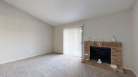 This one-bedroom, one-bathroom residence in Austin, TX is thoughtfully laid out across a single floor, offering a comfortable and efficient use of space. The living room serves as the heart of the home, featuring soft carpet flooring, a textured ceiling, and a charming brick wood-burning fireplace that adds warmth and character to the room. A sliding glass door with vertical blinds floods the space with natural light while providing access to the outdoors. The galley-style kitchen is equipped with wood cabinetry, light countertops, and black appliances including a range, over-the-range microwave, and refrigerator, all set atop durable wood-look vinyl flooring. The bedroom is a well-proportioned retreat with two windows that invite natural light, a ceiling fan with light fixture, and plush carpet underfoot. It connects to a generously sized walk-in closet with dual hanging rods and shelving, offering ample storage. The full bathroom features a wood-tone vanity with a light countertop, a tub-shower combination, and wood-look vinyl flooring. Neutral tones throughout the residence create a clean, move-in ready atmosphere suited for comfortable Austin living.
