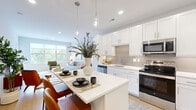 This thoughtfully designed 1-bedroom, 1-bathroom residence offers an efficient and comfortable single-floor layout. The open-concept kitchen flows seamlessly into the living area, creating a bright and inviting atmosphere. The kitchen is outfitted with white shaker-style cabinetry, quartz countertops, a tile backsplash, stainless steel appliances, and a central island with bar seating illuminated by pendant lighting. Light wood flooring extends throughout the space, contributing to a clean, modern aesthetic. The living room is bathed in natural light from a large window overlooking greenery, with a sliding door providing access to a private balcony. The bedroom is a tranquil retreat featuring a large window with outdoor views, ample natural light, and direct access to both the closet and the full bathroom. The closet offers built-in wire shelving for organized storage. The bathroom is finished with white cabinetry, quartz countertops, a wide vanity mirror, and a glass-enclosed shower, all in a bright, clean palette. Recessed lighting throughout the unit ensures a consistently well-lit environment. The overall ambiance is modern, light-filled, and efficiently laid out, making excellent use of every square foot.