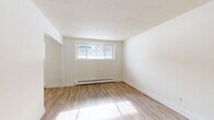 Located at 451 Leinster St in Woodstock, Ontario, this 2-bedroom, 1-bathroom unit offers a well-organized single-floor layout designed for comfortable everyday living. Light wood laminate flooring runs throughout the space, lending a clean and cohesive look to every room.

The galley-style kitchen is a standout feature, equipped with stainless steel appliances including a refrigerator, electric range, and over-the-range microwave. White shaker cabinetry, dark countertops, and a classic subway tile backsplash give the kitchen a modern, polished appearance. The kitchen connects directly to the combined dining and living area, creating a practical and open flow ideal for both daily use and entertaining.

The living room is bright and open, with light walls and generous floor space. Both bedrooms are well-proportioned, each featuring sliding double-door closets and light-filled windows. Baseboard heating is present in the bedrooms, ensuring warmth during cooler months. The primary bedroom offers a comfortable footprint suitable for a full bedroom setup.

The bathroom is finished with white subway tile surrounding a full soaker tub and shower, complemented by a window for natural light and ventilation. Two hallways connect the rooms efficiently, contributing to the unit's functional layout. Overall, the space presents a clean, updated, and move-in-ready interior.