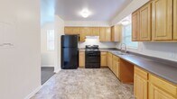 Located at 2002 Obear Ave in St. Louis, MO, this multi-floor residence offers 2 bedrooms and 2 bathrooms spread across three levels. The entry level features tile flooring and a louvered-door closet, providing a functional transition space into the home. The main floor hosts the kitchen and primary living areas. The kitchen is well-equipped with light wood cabinetry, gray countertops, black appliances including a range and refrigerator, a double sink, and tile flooring — all enhanced by natural light from two windows. A carpeted staircase with white-painted walls connects the floors. Both bedrooms are carpeted and finished with neutral cream walls and blinds-fitted windows that allow natural light. The primary bedroom features a generous double closet with six-panel doors, offering ample storage. The second bedroom is comparably sized and similarly finished. Two full bathrooms serve the home; one includes a tub-shower combo with white tile surround, and the other features a wood-toned vanity with a mirrored medicine cabinet and tile flooring. Clean white trim and a consistent neutral palette throughout give the home a cohesive, move-in-ready appearance.