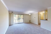 Located at 1105 Nalley Rd in Hyattsville, Maryland, this 2-bedroom, 1-bathroom residence offers a practical and comfortable single-floor layout. The open combined living and dining area serves as the heart of the home, featuring soft carpeting, crown molding, and a pendant light fixture. Large sliding glass doors lead to a private balcony overlooking lush greenery, filling the space with natural light and scenic outdoor views. The kitchen is well-appointed with warm wood cabinetry, dark granite-style countertops, tile flooring, stainless steel refrigerator, a gas range, and over-the-range microwave — offering efficient functionality in a compact footprint. Both bedrooms are carpeted and finished in neutral tones. The primary bedroom features a ceiling fan with light fixture and a window with natural light, while the second bedroom includes a sliding closet and connects easily to the hallway. The unit also provides three closets for ample storage and an in-unit laundry area for added convenience. A connecting hallway ties all rooms together in a cohesive, easy-to-navigate layout. The overall ambiance is calm, clean, and move-in ready, making it a practical choice in the Hyattsville area.