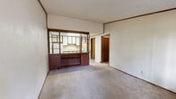 Located at 1500 Monument Rd in Jacksonville, FL, this one-bedroom, one-bathroom unit offers a practical and well-organized single-floor layout. The combined dining and living area serves as the heart of the home, finished with neutral carpet and crown molding throughout. A standout architectural feature is the retro-style open wood-framed room divider that separates the living space from the kitchen, complete with open shelving and a pass-through counter, adding both character and functionality. The kitchen is efficiently designed with ample white cabinetry accented by wood trim, a skylight for natural light, light wood-look vinyl flooring, a stainless steel sink, and full-size appliances including a refrigerator and range. The entrance area welcomes residents with a windowed front door and natural light from an adjacent window. The bedroom is a comfortable retreat featuring carpet, a ceiling fan with light, a window with outdoor views, and a full-width double bi-fold closet for generous storage. An additional closet provides extra storage elsewhere in the unit. The bathroom includes wood-look vinyl flooring, a vanity with sink, and a tub/shower combination equipped with accessibility grab bars. An in-unit laundry area adds everyday convenience to this thoughtfully arranged home.