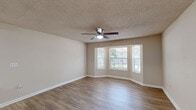 Located at 3200 Stone Rd SW in Atlanta, GA, this single-floor unit offers a practical and well-organized layout with two bedrooms, two bathrooms, a dedicated closet, and a combined kitchen and living area. Light-toned, hardwood-style flooring runs throughout the unit, lending a clean and cohesive look to the entire space. The spacious living room features a ceiling fan, textured ceiling, and neutral warm-beige walls, creating a comfortable, open atmosphere with access to the entry door. The kitchen is equipped with warm oak cabinetry offering ample storage, dark granite-style countertops, a double stainless steel sink, and black appliances including a range and refrigerator. A peninsula counter opens the kitchen toward the adjoining living area, facilitating an efficient flow between spaces. Both bedrooms are well-proportioned with neutral walls, hardwood-style flooring, and windows that bring in natural views of the surrounding greenery. The primary bedroom is generously sized and includes a ceiling fan. Both bathrooms are finished with white tile tub-shower combinations, offering clean and functional design. The unit also includes a closet for additional storage needs.