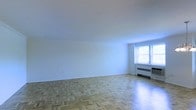 Located at 2 Hamilton Road in Morristown, NJ, this single-floor space offers a clean, minimalist interior defined by its classic parquet hardwood flooring, which adds warmth and timeless character throughout. The main living area is generously proportioned, with smooth white walls and a bright, neutral palette that creates an open, airy atmosphere. A window along the far wall allows natural light to filter into the room, illuminating the parquet floor pattern and contributing to the space's inviting feel. A wall-mounted radiator unit beneath the window suggests a traditional heating system consistent with well-established residential buildings in the area. The unobstructed layout of the main room offers flexibility for a variety of furniture arrangements. The smooth, white ceiling complements the light-toned walls, reinforcing the sense of openness. Overall, the space presents a straightforward, functional interior with enduring architectural details — most notably the parquet flooring — that lend a classic sensibility to the residence. Its location in Morristown, a historically rich and well-connected New Jersey community, adds further context to its appeal.
