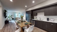 Located at 10920 Garfield Ave in South Gate, California, this single-floor residence showcases a thoughtfully designed open-concept layout with modern finishes throughout. The kitchen is a standout feature, equipped with dark espresso cabinetry extending to the ceiling, a white tile backsplash, light quartz countertops, and a full suite of stainless steel appliances including a gas range, dishwasher, microwave, and refrigerator. Wood-look flooring flows seamlessly from the kitchen into the dining area and living room, creating a cohesive and welcoming common space. The living room receives natural light through windows dressed with sheer curtains, contributing to an airy atmosphere.

The bedrooms offer comfortable retreats, each with neutral tones, carpeted flooring, and closet access. One bedroom features a dedicated workspace, while another is highlighted by a bold accent wall. The bathrooms are finished with dark vanity cabinetry, light countertops, and wood-look flooring. One bathroom includes a soaking tub and direct access to a walk-in closet with built-in shelving. Recessed lighting and a neutral color palette throughout the space contribute to a clean, contemporary ambiance.