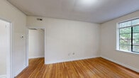 Located at 804 W Morgan St in Raleigh, NC, this one-bedroom, one-bathroom unit offers a practical and well-organized single-floor layout. Warm-toned hardwood floors flow throughout the living room, hallway, and bedroom, lending a cohesive and inviting character to the space. The living room is bright and welcoming, featuring a large multi-pane window that frames views of surrounding greenery and fills the room with natural light. A front door with an adjacent window further enhances the airy feel of this main gathering area. The bedroom is generously sized, accommodating a comfortable living arrangement, and includes an open closet alcove alongside additional storage options. Natural light enters through a large window overlooking lush trees, creating a tranquil atmosphere. The kitchen is functionally designed with warm wood cabinetry, granite-style countertops, stainless steel appliances including a range and refrigerator, and a dishwasher. Large windows bring in abundant natural light, making the kitchen feel open and pleasant. Light tile flooring completes the space. The bathroom features classic white square tile surrounding a full soaking tub with shower, a wood-toned vanity, and a frosted window for natural ventilation. Three closets throughout the unit provide ample storage for everyday living.