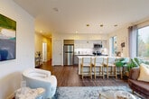 Located at 15446 Bel-Red Rd in Redmond, WA, this well-appointed 2-bedroom, 2-bathroom residence offers a thoughtfully designed single-level layout. The open-concept living, dining, and kitchen area serves as the heart of the home, featuring rich hardwood-style flooring, recessed lighting, and large windows that flood the space with natural light and frame lush Pacific Northwest greenery. The kitchen is outfitted with stainless steel appliances, two-tone cabinetry combining white uppers with wood-accented lowers, white quartz countertops, a breakfast bar with pendant lighting, and a window overlooking the outdoors. The living area opens to a private balcony through a glass sliding door, extending the living space outside. The primary bedroom is a serene retreat with a ceiling fan, a generous window with outdoor views, and a connected en-suite bathroom featuring a floating wood-tone vanity with a white quartz countertop and large mirror. The second bedroom is cozy and well-lit, complete with a sliding closet. The second bathroom includes a full soaking tub with clean white tile surround. Throughout, four closets provide ample storage, and a dedicated hallway and entrance add to the functional flow of this contemporary Redmond residence.