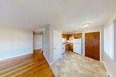 Located at 736 Campbell Ave in Ypsilanti, Michigan, this two-bedroom, one-bathroom single-story home offers a practical and functional layout. Warm hardwood flooring flows throughout the main living areas and bedrooms, lending a classic character to the space. The combined living and dining room is bright and open, with large windows that invite natural light and provide views of the surroundings. A dedicated entrance leads into the home's interior, connecting to a central hallway that links each room efficiently. The kitchen features warm wood cabinetry in an L-shaped configuration, complete with a white range, refrigerator, and sink, set atop tile flooring. Both bedrooms continue the hardwood flooring and are served by windows that bring in natural light; one bedroom includes a built-in closet with open shelving. Three closets throughout the home offer ample storage. The full bathroom includes a tiled tub and shower surround, a white vanity with sink, and a toilet, finished in neutral tones. A utility room and additional unclassified space provide further functional square footage. The overall ambiance is clean, neutral, and move-in ready, with a simple and efficient design suited for comfortable everyday living.