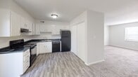 Located at 5455 Countryside Dr in Winston-Salem, NC, this single-floor unit offers three bedrooms and one bathroom within a efficiently arranged floor plan. The kitchen features white cabinetry with dark granite-style countertops, wood-look vinyl plank flooring, and black appliances including a refrigerator, dishwasher, and range. A closet adjacent to the kitchen provides additional storage. The living area transitions seamlessly from the kitchen and is finished with neutral carpet and light-toned walls, creating a cohesive aesthetic throughout the common spaces.

The generously sized primary bedroom offers ample room for furnishings, complemented by a ceiling fan, a window for natural light, and a louvered closet door. The two additional bedrooms are similarly appointed with plush carpet, ceiling fans, natural light from windows, and sliding or standard closet doors, providing practical storage in each room. A hallway connects the bedrooms to the shared full bathroom, which includes a vanity with dark countertop, a tub/shower combination, and wood-look vinyl flooring. Clean white walls and consistent finishes carry throughout, giving the entire unit a tidy, move-in-ready appearance.