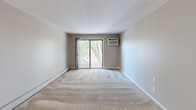 Located at 3 Danforth Dr in Nashua, NH, this one-bedroom, one-bathroom apartment offers a well-organized single-floor layout designed for comfortable everyday living. The unit spans a compact yet efficient footprint, making smart use of every room.

The kitchen is a standout feature, outfitted with crisp white shaker-style cabinetry, stone-look countertops, light wood-tone flooring, and black appliances including a full-size refrigerator and range. A stainless steel sink and ample counter space complete this functional cooking area.

The spacious living room is carpeted and filled with natural light, featuring sliding glass doors that open to a private balcony with outdoor views of mature trees. A wall-mounted air conditioning unit and baseboard heating ensure year-round comfort.

The bedroom is generously sized, also carpeted, and includes a window with wooded views and baseboard heating. It provides access to a dedicated closet, offering practical storage solutions.

The bathroom is clean and well-appointed, featuring a full tub-shower combination with a white surround, chrome fixtures, and tile flooring. Neutral wall tones throughout the unit create a cohesive, understated aesthetic that adapts easily to a variety of décor styles.