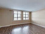 Located on Olive Street in the vibrant Central West End neighborhood of St. Louis, this well-appointed one-bedroom, two-bathroom residence offers a thoughtfully designed single-floor layout with a generous total living area. The combined living and dining room serves as the heart of the home, featuring rich hardwood-style flooring, crown molding, and multiple windows fitted with blinds that frame views of the surrounding cityscape. The space opens naturally toward a dedicated den, providing flexible options for a home office or additional lounge area. The kitchen is equipped with light maple cabinetry, black appliances including a refrigerator with ice maker and an electric range, a double-basin sink, and contrasting countertops, complemented by dark tile flooring. A pantry and utility room add practical storage and functional support. The spacious primary bedroom is carpeted and lined with multiple windows on two walls, filling the room with natural light and city views. It is served by a well-appointed bathroom featuring a soaking tub, a glass-enclosed shower, tile flooring, and a vanity with warm wood cabinetry. Two closets, including a walk-in with wire shelving, offer ample storage. A tiled hallway connects all areas seamlessly, and in-unit laundry adds everyday convenience.