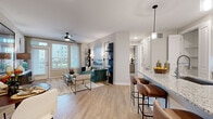 Located in Humble, TX, this well-appointed 2-bedroom, 2-bathroom single-story home offers a thoughtfully designed open-concept layout that seamlessly connects the kitchen, dining, and living areas. Light wood-look flooring flows throughout the main living spaces, enhancing the bright and airy atmosphere.

The kitchen is a standout feature, boasting crisp white cabinetry, a striking blue geometric tile backsplash, stainless steel appliances, and a generous granite-topped island with bar seating and pendant lighting overhead — ideal for both cooking and casual dining.

The living room is bathed in natural light from large windows and a glass-paned exterior door, complemented by a ceiling fan and a built-in accent niche. The primary bedroom offers a comfortable retreat with plush carpet, natural light from a window with outdoor views, and an en-suite bathroom featuring a dual-sink granite vanity, wood-look flooring, and a glass-enclosed walk-in shower. The second bathroom includes a granite vanity and a full tub-shower combination with tile surround. The second bedroom provides a cozy, well-lit space with carpeted flooring and outdoor views. Additional spaces include a dedicated office and a closet, rounding out this functional and stylish home.