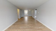 Located at 134 College Hwy in Southampton, MA, this single-floor unit offers a clean, straightforward layout designed for comfortable everyday living. The main living area is generously proportioned, featuring light-toned hardwood floors that run throughout and soft gray walls that create a calm, neutral atmosphere. Natural light filters in through multiple windows, enhancing the open feel of the space.

The kitchen is neatly appointed with white cabinetry, marble-patterned countertops, a tile backsplash, a stainless steel sink, and white appliances including a dishwasher and range. A window above the sink brings in additional natural light, making the space feel bright and airy.

The bedrooms are well-sized and share the same hardwood flooring found throughout the unit. A distinctive feature in the bedroom areas is the bold grid-patterned tiled accent wall, adding a unique textural element to the otherwise minimal design. Baseboard heating is present throughout, ensuring warmth during cooler months.

The full bathroom is clean and functional, featuring a white vanity with storage, a tiled tub-shower combination, a medicine cabinet, and tile flooring. The overall aesthetic of the space is consistent — light, neutral, and move-in ready, offering a practical and comfortable living environment in a quiet Southampton setting.