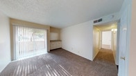 Located at 4602 54th St in Lubbock, Texas, this single-floor residence offers a practical and functional layout throughout. The entry foyer welcomes visitors with tile flooring and a ceiling fan overhead, opening into a carpeted living area bathed in natural light from a large sliding glass door fitted with vertical blinds. A built-in credenza adds useful storage to the living space, which connects seamlessly to the rest of the home.

The kitchen features light-toned cabinetry, laminate countertops, a double-basin sink, and an electric range with overhead ventilation, all set atop durable dark wood-style flooring. The space is efficiently organized to maximize functionality.

The bedrooms are carpeted and outfitted with ceiling fans and natural light from windows with blinds, providing a comfortable and well-ventilated environment. Each room offers clean, neutral walls that allow for versatile use.

The bathroom includes a full tub-shower combination with a curved curtain rod, a toilet, overhead cabinetry for storage, and a vanity with a speckled countertop and wall-mounted mirror with lighted fixture above. Textured ceilings are present throughout the home, contributing to its consistent interior character.