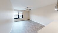 Located at 900 Third St SE in Cedar Rapids, Iowa, this single-floor unit offers a thoughtfully designed layout that maximizes functionality and comfort. The space is finished with light-toned luxury vinyl plank flooring throughout, providing a clean and cohesive look across all rooms.

The kitchen is a standout feature, outfitted with warm taupe shaker-style cabinetry extending to the upper walls for generous storage, complemented by light quartz countertops and a full suite of stainless steel appliances, including a range, over-the-range microwave, and refrigerator. Recessed lighting illuminates the kitchen efficiently.

The living room offers an open, airy feel with a large window that brings in natural light and provides views of the surrounding Cedar Rapids streetscape. A ceiling fan adds both style and practical comfort to the space.

The bathroom is well-sized and features a dark wood vanity with a white countertop and sink, a large mirror, and a full tub-shower combination with a curtain rod. Light vinyl flooring and neutral wall tones keep the space bright and clean.

A dedicated closet provides additional storage. The unit's overall design is modern and neutral, making it a versatile and move-in-ready space in the heart of Cedar Rapids.