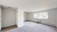 Located at 4214 Longshore Ave in Philadelphia's 19135 neighborhood, this one-bedroom, one-bathroom unit is thoughtfully designed to maximize its compact footprint. The layout flows from a welcoming entrance into a combined living and dining area, where soft wall-to-wall carpeting, neutral white walls, and large windows allow natural light to fill the space. A wall-mounted air conditioning unit and baseboard heating ensure year-round comfort in the living room, which also features a closet near the entry. The kitchen connects conveniently to the dining area and features hard-surface flooring, offering a practical contrast to the carpeted main living spaces. The generously sized bedroom provides ample room for furnishings and is outfitted with a double-door closet offering substantial storage, along with a window that brings in natural light. The clean, white bathroom includes a vanity with under-sink cabinetry, a mirrored medicine cabinet, and a shower/tub combination, all set on wood-look vinyl flooring. With two closets throughout the unit, practical storage is well accounted for. The overall aesthetic is clean, bright, and move-in ready, presenting a functional and comfortable living space.
