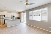 Located at 870 S Sarival Ave in Goodyear, AZ, this well-designed one-bedroom, one-bathroom home offers a clean, modern aesthetic throughout its thoughtfully laid-out single floor. Light wood-look flooring flows seamlessly through every room, creating a cohesive and airy atmosphere.

The open-concept kitchen and living area serves as the heart of the home. The kitchen is outfitted with white shaker-style cabinetry extending to the ceiling, a granite-topped island with an undermount sink, stainless steel appliances including a refrigerator, electric range, microwave, and dishwasher. A ceiling fan overhead and a sliding glass door leading to an outdoor patio fill the living area with natural light.

The bedroom is a comfortable, well-proportioned retreat featuring dual windows that invite natural light, a ceiling fan, and a closet accessible via the hallway. The hallway connects the main living spaces and includes additional storage with a thermostat conveniently mounted on the wall.

The bathroom is finished with white cabinetry, a quartz countertop vanity, an undermount sink with brushed nickel hardware, and a window that provides natural ventilation. The neutral gray tones throughout the home lend a calm, modern feel, making this Goodyear residence a practical and attractive living space.