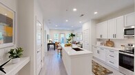 Located at 1801 Riverside Parkway in Douglasville, GA, this well-appointed one-bedroom, one-bathroom residence offers a thoughtfully designed single-floor layout with clean, modern finishes throughout. The open-concept kitchen and living area forms the heart of the home, where a sleek white kitchen island with a undermount sink and quartz countertops anchors the space. White shaker cabinetry, subway tile backsplash, and stainless steel appliances — including a refrigerator, range, microwave, and dishwasher — complete the kitchen. Light wood-style flooring extends through the main living area, which opens to a private balcony through glass doors, allowing natural light to fill the room. The living area provides a versatile layout suitable for both relaxing and working from home. The spacious primary bedroom features plush carpeting, vaulted ceilings with a ceiling fan, and double windows overlooking greenery. The full bathroom is finished with white tile, a tub-shower combination, a white vanity, and tile flooring. A dedicated laundry room with washer and dryer hookups and a separate closet add practical convenience to this well-rounded residence.