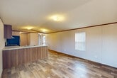 Located at 3115 Glenarm Rd in Colorado Springs, Colorado, this single-story, 3-bedroom, 2-bathroom home offers a functional and well-organized layout. The open-concept kitchen and living area forms the heart of the home, featuring wood-look laminate flooring that extends throughout. The kitchen is equipped with warm wood-toned cabinetry, granite-look countertops, a gas range, a black refrigerator, and a central peninsula with an integrated sink — providing both prep space and a casual dining option. Vaulted ceilings with crown molding trim add a sense of openness to the shared living space, which receives natural light through blinds-fitted windows. The three bedrooms are comfortably sized, with the primary bedroom offering generous closet access. Multiple closets are distributed throughout the home, providing ample storage. The two bathrooms are efficiently designed, each featuring wood-toned vanities topped with granite-look counters and mirrored storage. A hallway connects the bedroom wing to the main living areas, and two entrances provide convenient access. The consistent wood-look flooring, neutral wall tones, and warm cabinetry finishes create a cohesive and practical interior throughout.