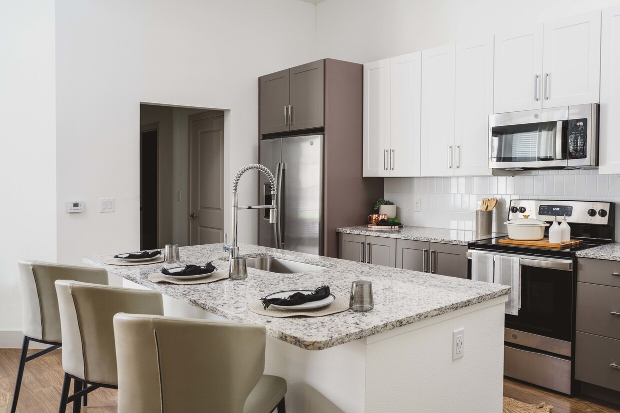 Gourmet kitchens with granite countertops and tile backsplashes - Modera Frisco Square