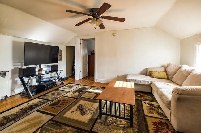 Living with original hardwood floors, ceiling fan, windows filled with natural light - 521 Bay St