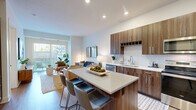 Located at 3250 W 66th St in Edina, MN, this thoughtfully designed one-bedroom, one-bathroom residence offers a efficient yet comfortable layout across a single floor. The open-concept living and kitchen area serves as the heart of the home, bathed in natural light from large sliding glass doors that lead to an outdoor space with views of surrounding greenery. The living area features clean white walls, light wood-style flooring, and ample room for relaxed seating arrangements. The kitchen is a standout feature, showcasing rich walnut-toned cabinetry reaching to the ceiling, a herringbone tile backsplash, stainless steel appliances including a refrigerator, range, microwave, and dishwasher, and a central island with bar seating — ideal for both cooking and casual dining. The bedroom offers a calm, well-lit retreat with a natural window, carpeted flooring, and direct access to a dedicated closet. The bathroom is finished with wood-grain cabinetry, a white quartz countertop, a tub-shower combination with tile surround, and light wood-style flooring, creating a cohesive and modern aesthetic. Throughout the unit, the design strikes a balance between contemporary style and everyday functionality.
