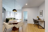 Located at 2600 Cavendish Boulevard in Montréal, this well-designed 2-bedroom, 1-bathroom unit is part of the Citizia residential development, offering urban comfort with a clean, modern aesthetic throughout. Light hardwood flooring flows seamlessly across the single-floor layout, connecting each room with a sense of cohesion and warmth.

The open living and dining area serves as the heart of the unit, featuring a round wood dining table with contemporary seating, a dedicated workspace, and a comfortable living room anchored by floor-to-ceiling sheer curtains that allow abundant natural light to fill the space. The living area is styled with a green velvet sofa, a statement arc floor lamp, and a sleek media console.

The kitchen is outfitted with grey cabinetry, light countertops, and stainless steel appliances, including a full-size refrigerator, stove, and dishwasher, offering a practical and stylish cooking space.

The primary bedroom is a serene retreat, bathed in natural light through sheer curtains and featuring a closet and decorative wall art. The second bedroom provides additional flexible living space. The bathroom is finished with large-format grey stone-effect tiles, a floating vanity with under-mount sink, and a clean white palette that conveys a spa-like simplicity.