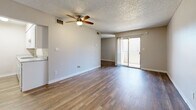 Located at 10201 N 33rd Ave in Phoenix, Arizona, this efficiently designed single-floor unit offers a thoughtful layout that makes excellent use of its intimate footprint. The main living area is open and welcoming, finished with durable wood-look plank flooring that runs throughout and neutral beige walls that lend a clean, bright aesthetic. A ceiling fan with an integrated light fixture anchors the room, providing both comfort and illumination. A textured popcorn ceiling adds a classic touch overhead, while a sliding glass door floods the space with natural light and opens to a private balcony — ideal for enjoying the Arizona sunshine. A sliding closet door provides convenient built-in storage within the living area. The kitchen is tucked neatly along one wall, featuring white cabinetry and a stainless steel oven range, offering functional cooking space without sacrificing the open feel of the room. The bathroom is well-appointed with wood-look tile flooring, white cabinetry, a granite-style countertop vanity with a large mirror, and a shower/tub combination. Clean, neutral finishes throughout ensure a cohesive and move-in-ready atmosphere. This unit is a practical and comfortable option in the heart of Phoenix.