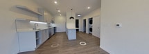 This 670 square foot apartment showcases a modern, open-concept design that maximizes space efficiency. The heart of the home is a sleek kitchen featuring white cabinetry, stainless steel appliances, and a substantial island that doubles as a dining area. The kitchen seamlessly flows into a spacious living room, characterized by large windows that flood the space with natural light and offer views of the surrounding suburban landscape.

The flooring throughout is a durable wood-look material, adding warmth and continuity to the space. Recessed lighting in the ceiling contributes to the contemporary ambiance, complemented by a statement pendant light over the kitchen island.

The bathroom, while not extensively shown, appears to feature a modern shower with clean, white tile work and updated fixtures. The overall color palette of the apartment is neutral, with whites and light grays dominating, creating a bright and airy feel.

Storage seems ample, with numerous cabinets in the kitchen and likely additional closet space not visible in the images. The layout is designed for easy movement and functionality, ideal for modern living. The large windows not only provide natural light but also create a sense of expanded space, making the apartment feel larger than its 670 square feet.