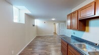 This one-bedroom, one-bathroom unit at 1125 S Walnut St in Muncie, Indiana offers a well-organized, single-floor layout designed for comfortable everyday living. Warm hardwood-style flooring runs consistently throughout the space, creating a cohesive and inviting atmosphere from room to room.

The kitchen is a functional highlight, featuring rich wood cabinetry, dark granite-style countertops, a double-basin sink, and full appliances including a gas range with overhead microwave, and a full-size refrigerator. The kitchen flows naturally into the main living area, which includes a wall-mounted TV bracket, offering a convenient, ready-to-use setup.

The bedroom is a quiet, comfortable retreat with neutral beige walls and a window positioned to bring in natural light, adding brightness to the cozy space. An adjacent closet provides dedicated storage. Two arched interior doors connect the living and sleeping areas, adding a subtle architectural detail to the overall design.

The bathroom is clean and straightforward, featuring a full tub-shower combo with built-in shelving, a toilet, and a wood-tone vanity. The same hardwood-style flooring extends into the bathroom, maintaining visual consistency throughout the unit. This practical and neatly appointed unit is an excellent option for those seeking efficient, move-in-ready living in Muncie.
