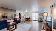 Located at 138 S Atherton Street in State College, PA, this two-bedroom, one-bathroom residence offers a functional and comfortable single-floor layout. The open living and dining area is a central highlight, featuring light wood-style flooring, large vertical-blind windows that invite natural light, and a mirrored accent wall that adds depth to the space. The living area flows seamlessly into a dedicated dining space, making it well-suited for everyday living and entertaining. The galley-style kitchen is efficiently designed with rich cherry wood cabinetry, white appliances including a range and refrigerator, and tile flooring, providing ample counter and storage space. The primary bedroom is generously sized and includes a large dark wood bi-fold closet, providing substantial storage. The second bedroom also accommodates two sleeping areas and features its own closet, a bright window with outdoor views, and a white shiplap-style accent wall. The full bathroom is well-appointed with a tiled tub-shower combination with glass sliding doors, a single vanity with dark wood cabinetry, and classic white tile flooring. Three closets throughout the unit offer additional storage. Hardwood-style flooring flows through the main living areas, tying the space together cohesively.