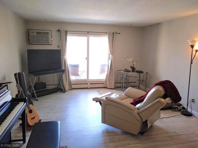 Living room with balcony looking over green space and courtyard - 7414 W 22nd St