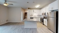 Located at 6612 Century Ave in Middleton, Wisconsin, this well-appointed single-floor unit offers a thoughtfully designed layout with modern finishes throughout. The kitchen serves as a central highlight, featuring white shaker-style cabinetry, a subway tile backsplash, granite countertops, a large center island with pendant lighting, and a full suite of stainless steel appliances including a range, microwave, and refrigerator. Light wood-look flooring flows through the kitchen and living areas, contributing to a clean, contemporary aesthetic. The living area is spacious and bright, with a ceiling fan and sliding glass doors that open to a private balcony, offering views of the surrounding community. The bedrooms are carpeted for comfort and include ceiling fans and large windows that bring in natural light — one overlooking lush greenery and another with views of the neighborhood. The bathroom is well-appointed with a granite-topped vanity, wood-toned cabinetry, and wood-look tile flooring, delivering a polished, cohesive look. An additional powder room provides added convenience. Overall, the space presents a fresh, neutral palette with modern hardware and fixtures throughout, creating a clean and functional living environment.