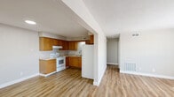 Located at 322 W 65th St in Davenport, Iowa, this two-bedroom, one-bathroom unit offers a practical and well-organized single-floor layout. Warm-toned vinyl plank flooring flows consistently throughout the entire space, creating a cohesive and easy-to-maintain interior.

The kitchen is outfitted with classic oak cabinetry, light countertops, a double-basin sink, and white appliances including a range and refrigerator. It opens toward the living area, making the space feel connected and accessible. Adjacent to the kitchen is a dining or flex area illuminated by a recessed ceiling light.

The living room features neutral gray walls, large windows fitted with blinds, and a private entry door with a small utility access panel along one wall, adding functional storage.

Both bedrooms continue the vinyl plank flooring and neutral color palette. Each room includes a closet with a hanging rod, and natural light enters through sizable windows with blinds. The primary bedroom offers a generous footprint with direct access to the full bathroom.

The bathroom includes a single-sink vanity with oak cabinetry, a full tub-shower combo with a white surround, and coordinating brushed nickel fixtures. The textured ceiling detail carries through several rooms, adding a subtle design element throughout the unit.